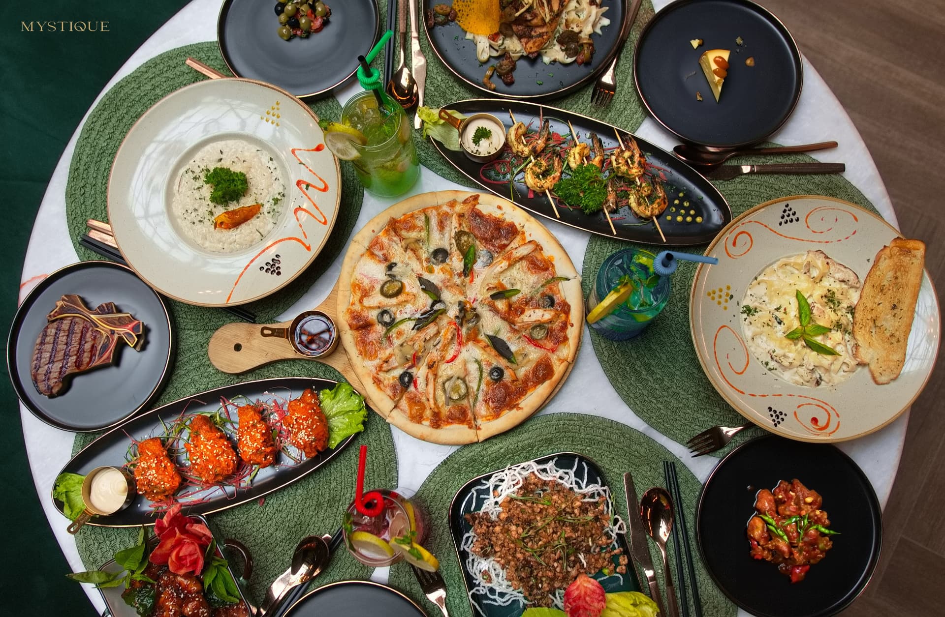 An overhead spread of Mystique dishes on a set table