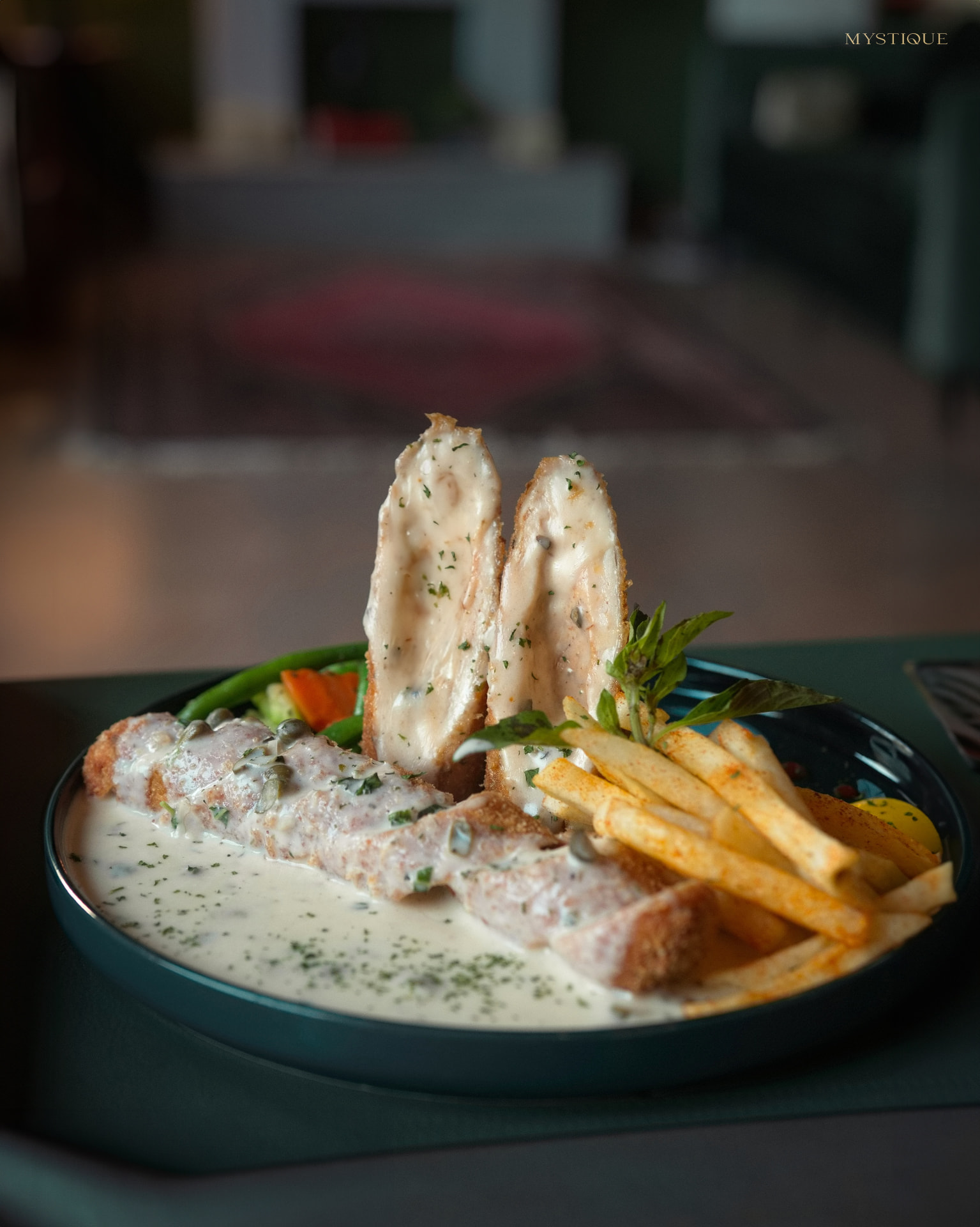 A creamy chicken dish served with fries at Mystique