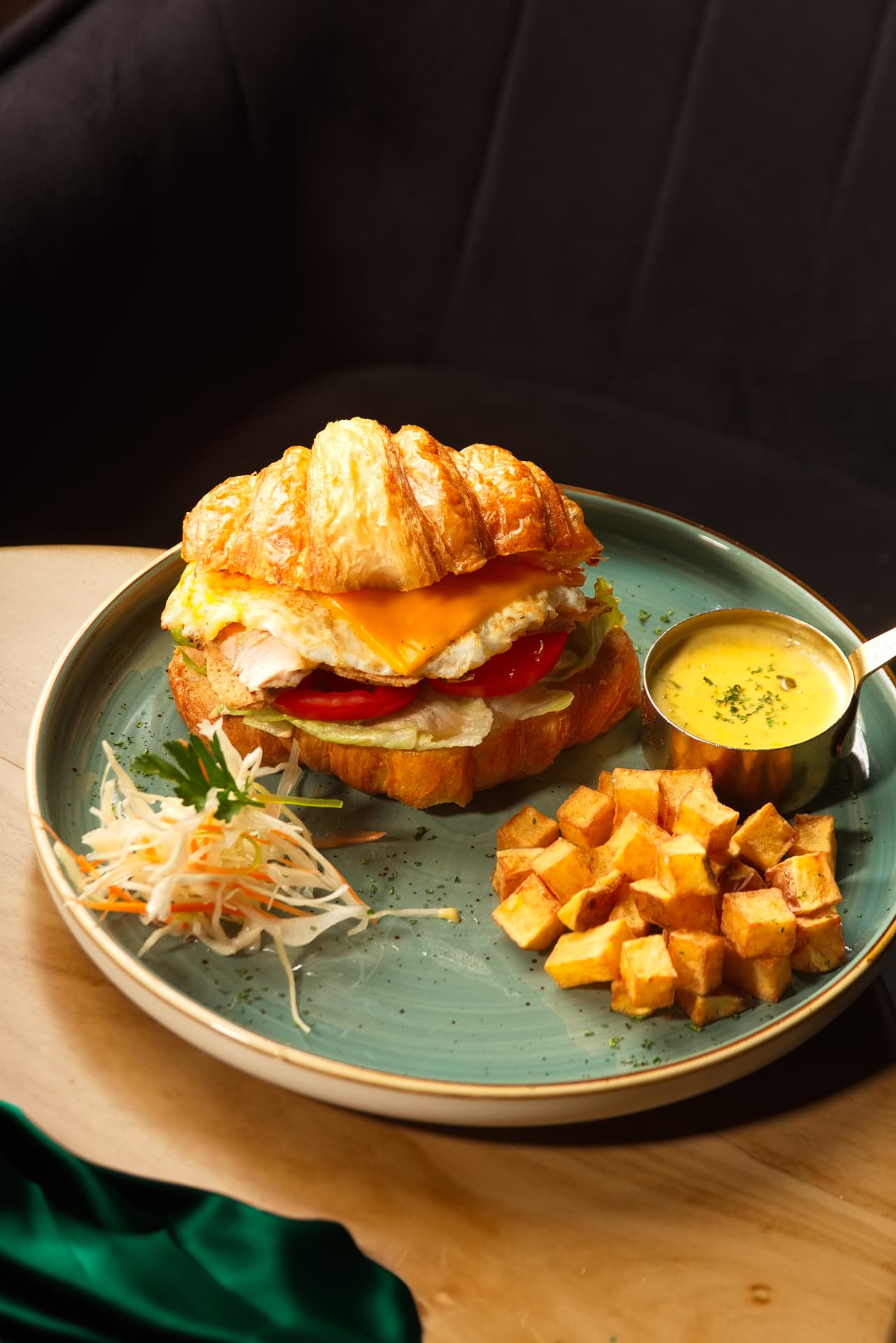 Breakfast croissant with egg, cheese and potatoes
