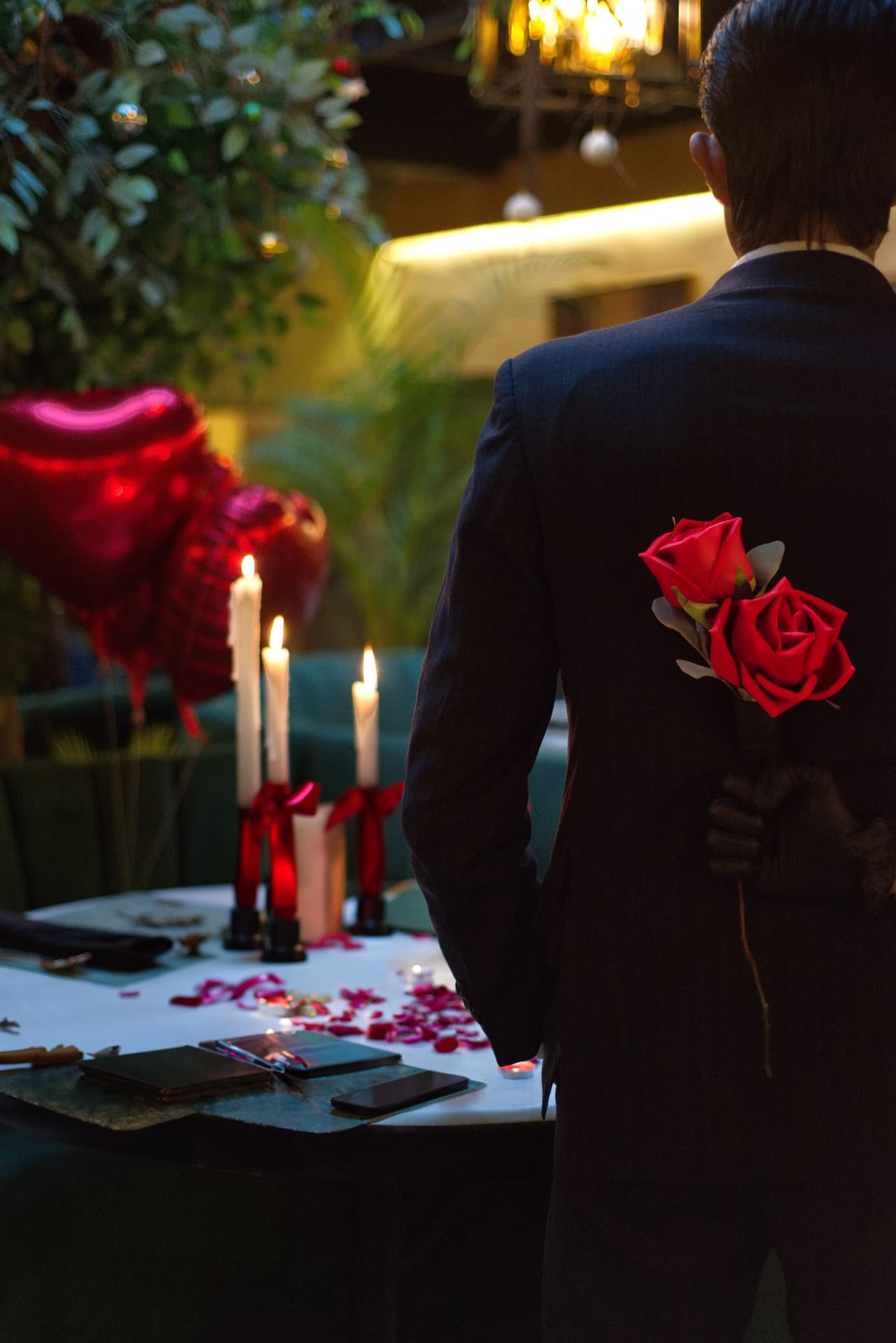 A surprise celebration — roses behind the back, candles aglow